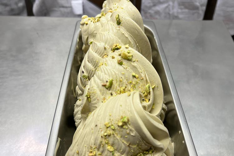 Krämig pistagegelato vackert upplagd i en metallbehållare