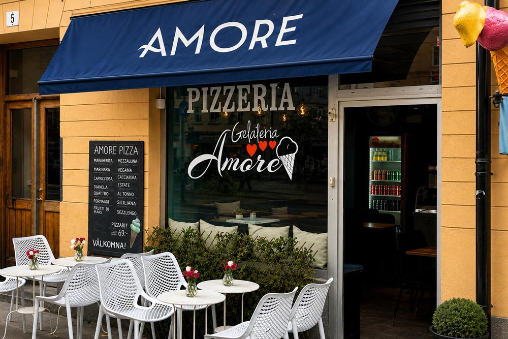 Restaurang Amores entré med blå markis. I skyltfönstret syns restaurangens logotyp, och framför entrén står vita utemöbler med små blomvaser.